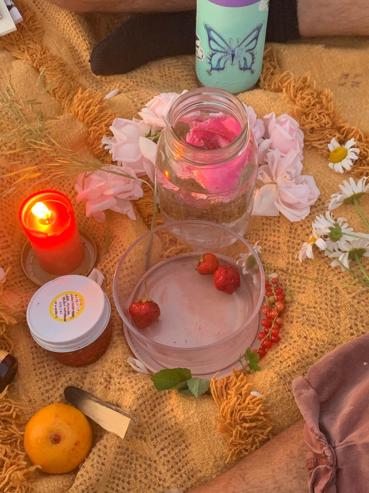 A photo of an altar with strawberries and a candle